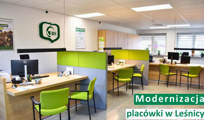 Trzy osoby siedzące przy drewnianym stole – doradczyni bankowa w czarnym żakiecie oraz para klientów. Na stole leżą dokumenty i otwarty laptop, a doradczyni wskazuje coś na ekranie smartfona. W lewym górnym rogu logotyp Banku Spółdzielczego w Leśnicy. Na dole napis: „Oszczędności. Dlaczego warto mieć finansową poduszkę bezpieczeństwa?”