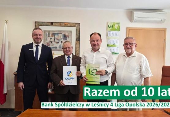 Trzy osoby siedzące przy drewnianym stole – doradczyni bankowa w czarnym żakiecie oraz para klientów. Na stole leżą dokumenty i otwarty laptop, a doradczyni wskazuje coś na ekranie smartfona. W lewym górnym rogu logotyp Banku Spółdzielczego w Leśnicy. Na dole napis: „Oszczędności. Dlaczego warto mieć finansową poduszkę bezpieczeństwa?”
