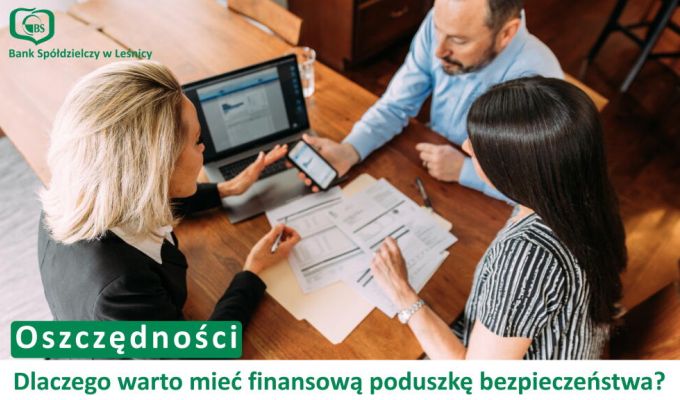 Trzy osoby siedzące przy drewnianym stole – doradczyni bankowa w czarnym żakiecie oraz para klientów. Na stole leżą dokumenty i otwarty laptop, a doradczyni wskazuje coś na ekranie smartfona. W lewym górnym rogu logotyp Banku Spółdzielczego w Leśnicy. Na dole napis: „Oszczędności. Dlaczego warto mieć finansową poduszkę bezpieczeństwa?”